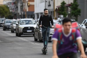 Así, no. Un usuario transita en su monopatín eléctrico por calle Rivadavia, sin casco protector.