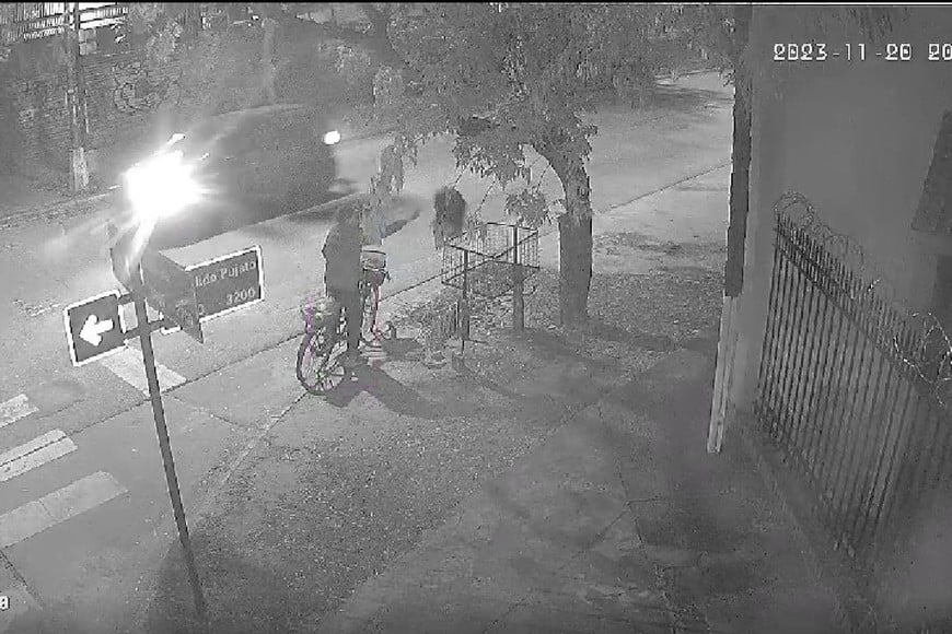 El colmo. Un hombre llega en bicicleta y arroja en el cesto en altura que no le pertenece su bolsita de residuos domiciliarios.